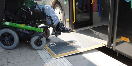 Ein Rollstuhfahrer fährt über eine Rampe in einen RSV Bus