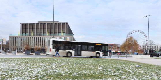 Ein Bus fährt im Winter vor der Stadthalle Reutlingen.