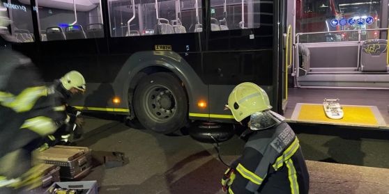 Feuerwehrmänner heben für eine Übung einen RSV Bus an