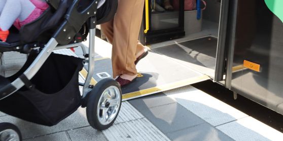 An einem Bus ist eine Rampe ausgeklappt um Rollstuhlfahrern und Kinderwagen den Einstieg zu erleichtern