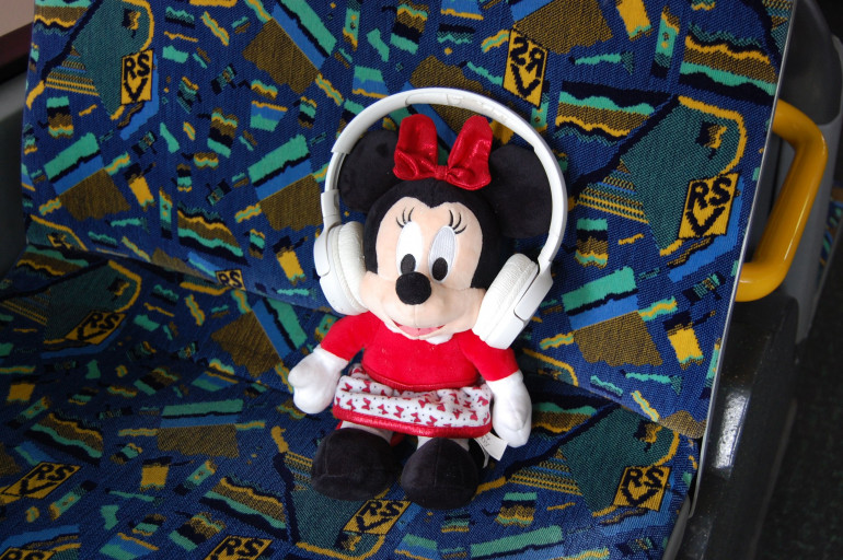 Fundstück Kuscheltier Mini Maus sitzt mit gefundenen Kopfhörern im Bus