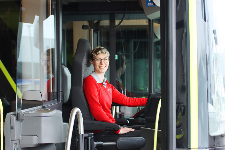 Auszubildende sitzt nach bestandener IHK Prüfung am Steuer eines RSV Busses
